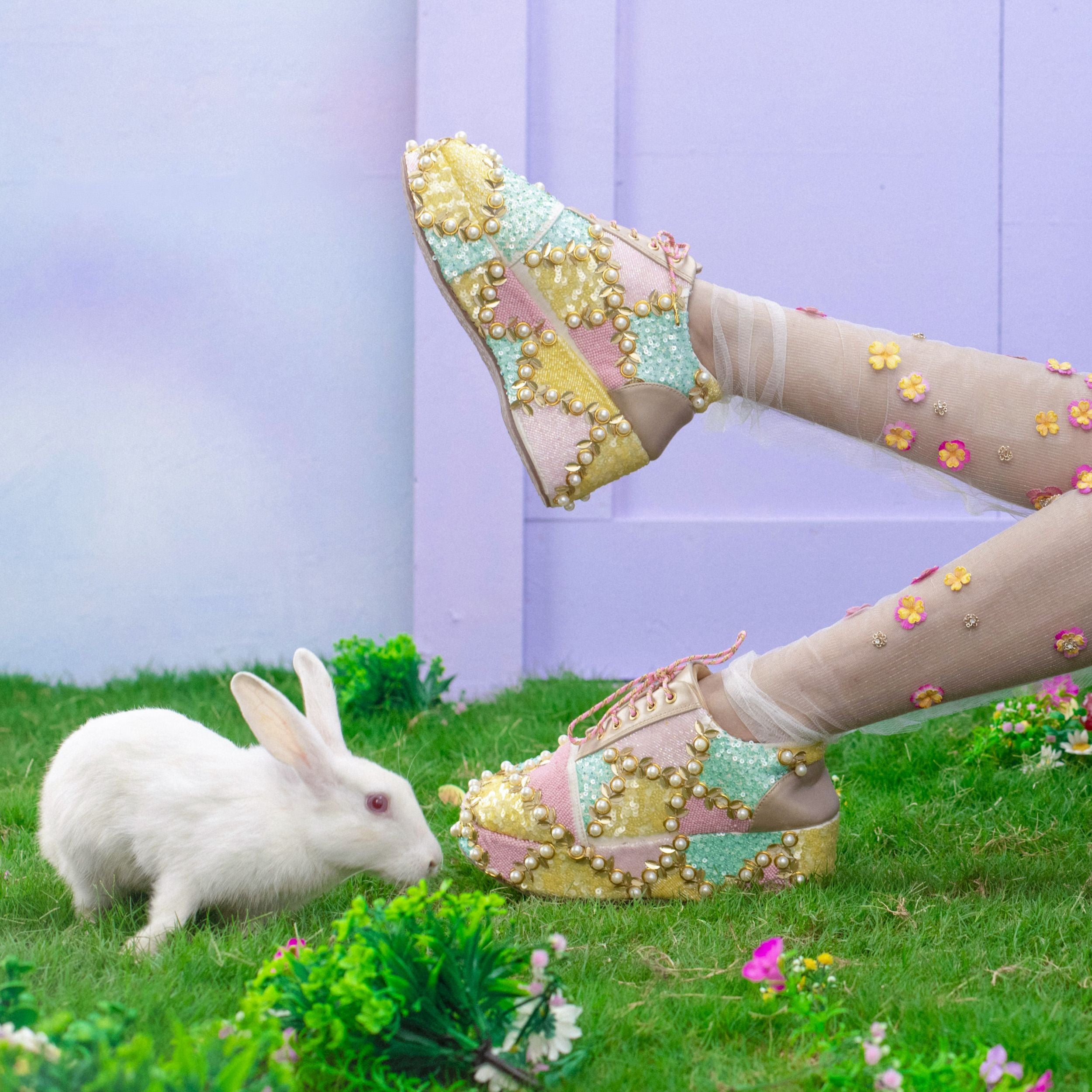 Pastel lace-up sneakers with sequin and pearl embroidery on grass