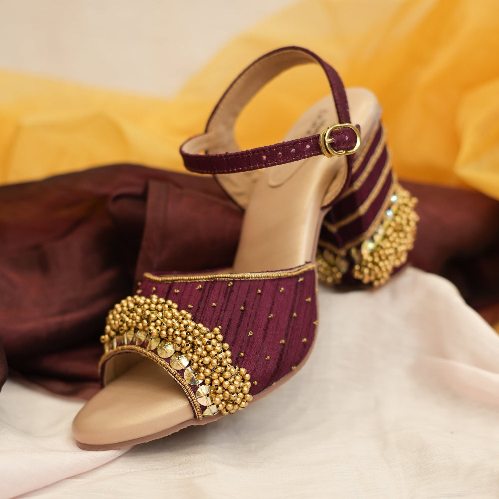 Burgundy wedge sandals with gold detailing and ankle straps
