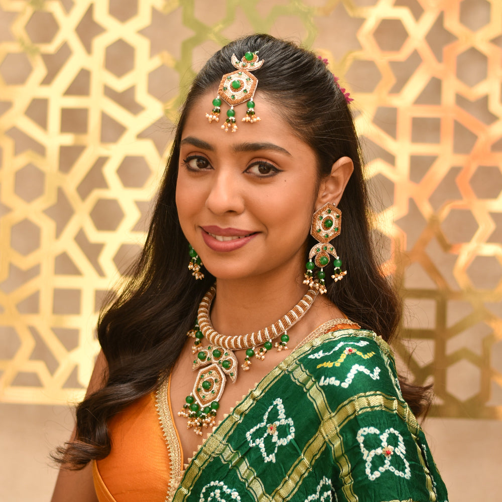 Indian bride wearing a green and golden handcrafted jewellery set for her ethnic wedding look