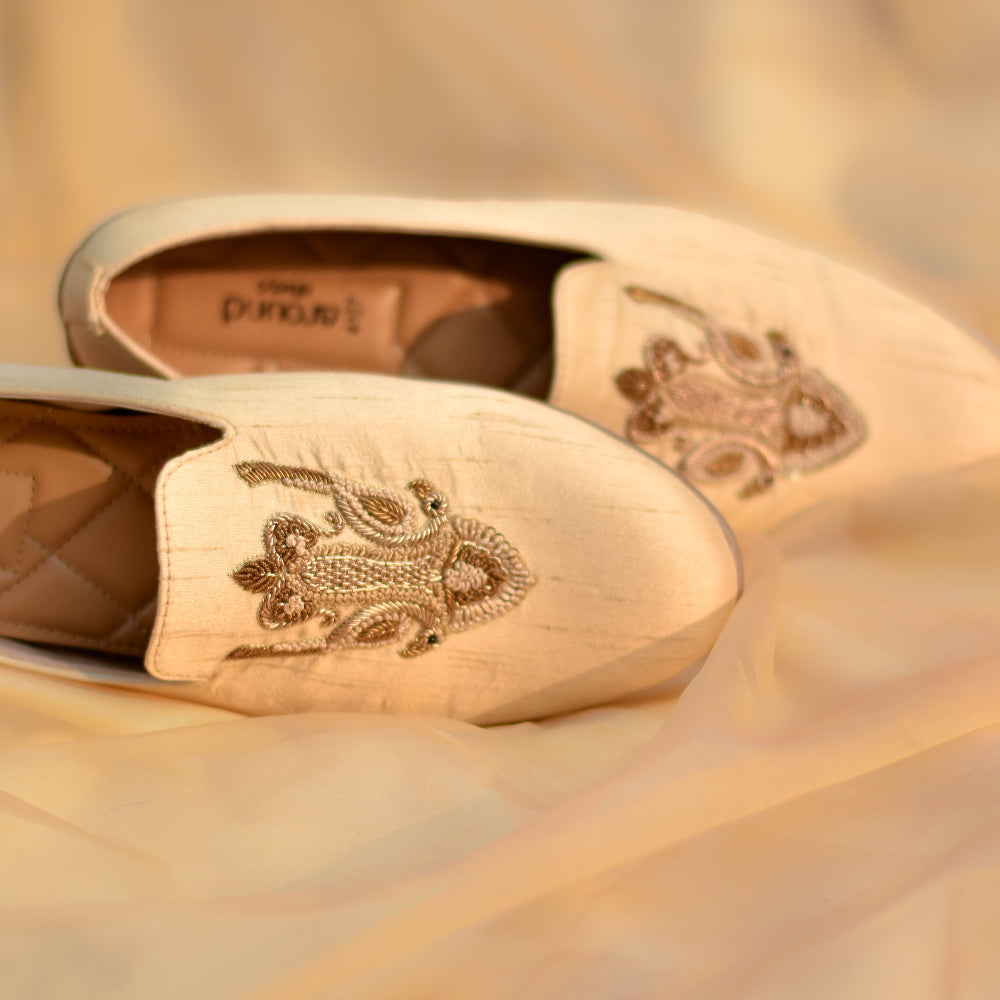 Beige footwear highlighting artisanal detailing and quilted comfort