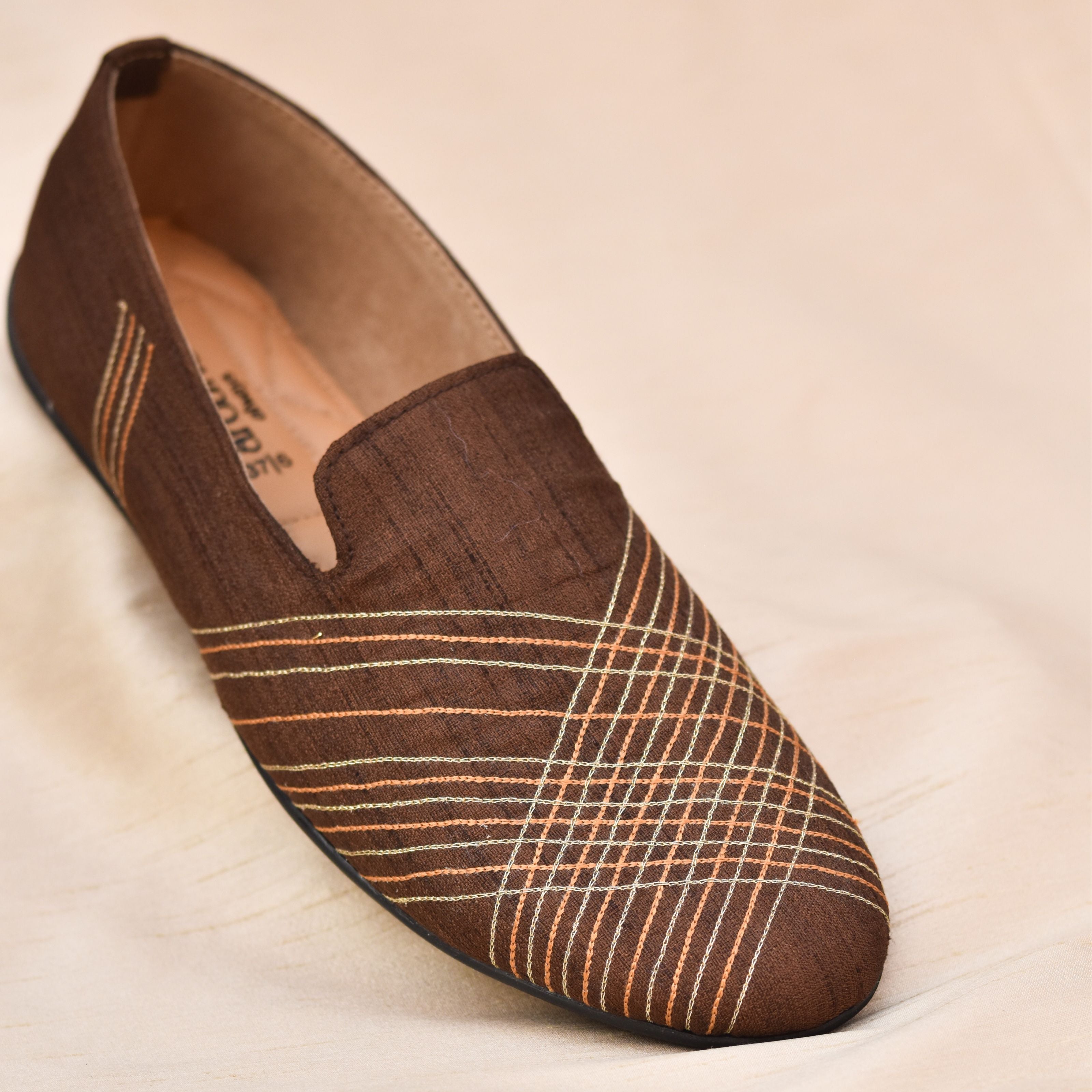 Brown groom loafers with geometric embroidery and cushioned insole.