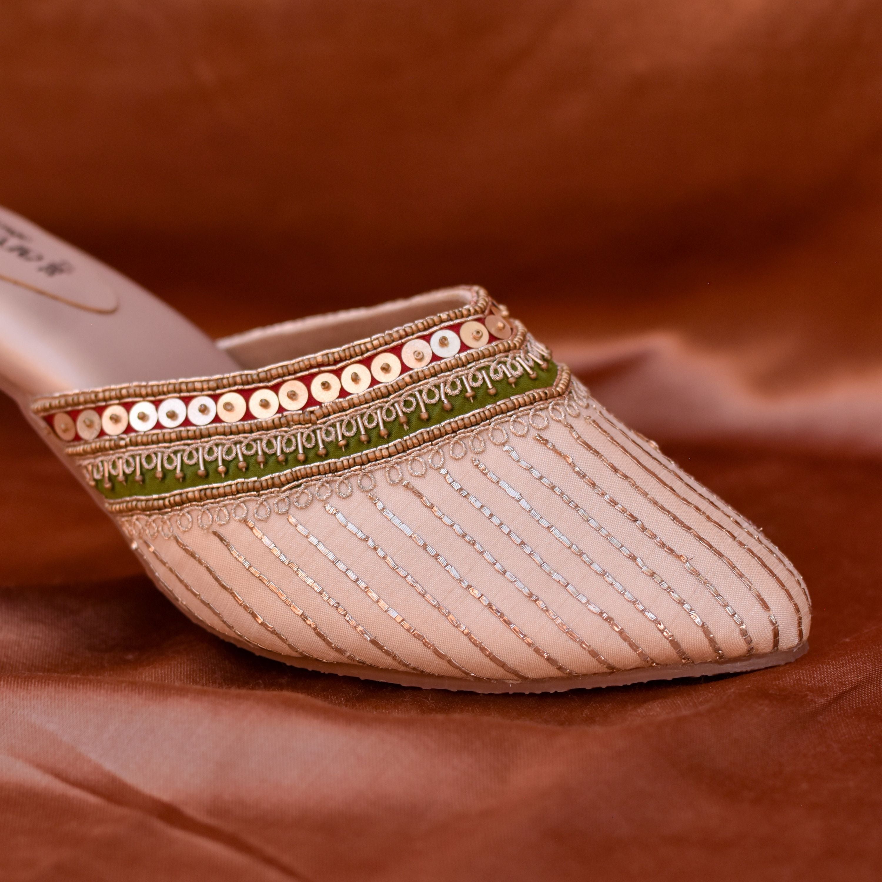 Traditional golden mules with green and red sequin border for women.