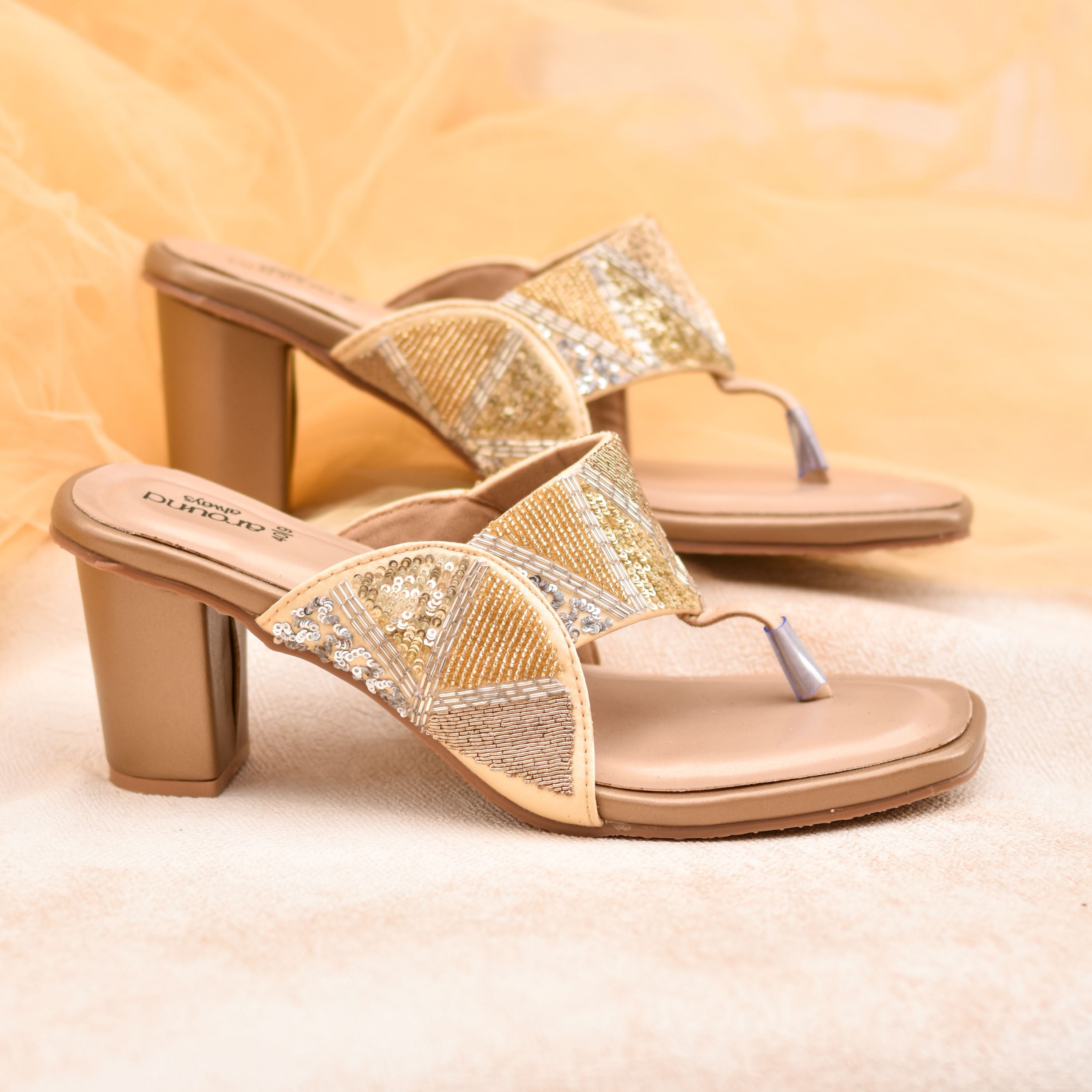 Golden block heel sandals with sequin geometric strap design.