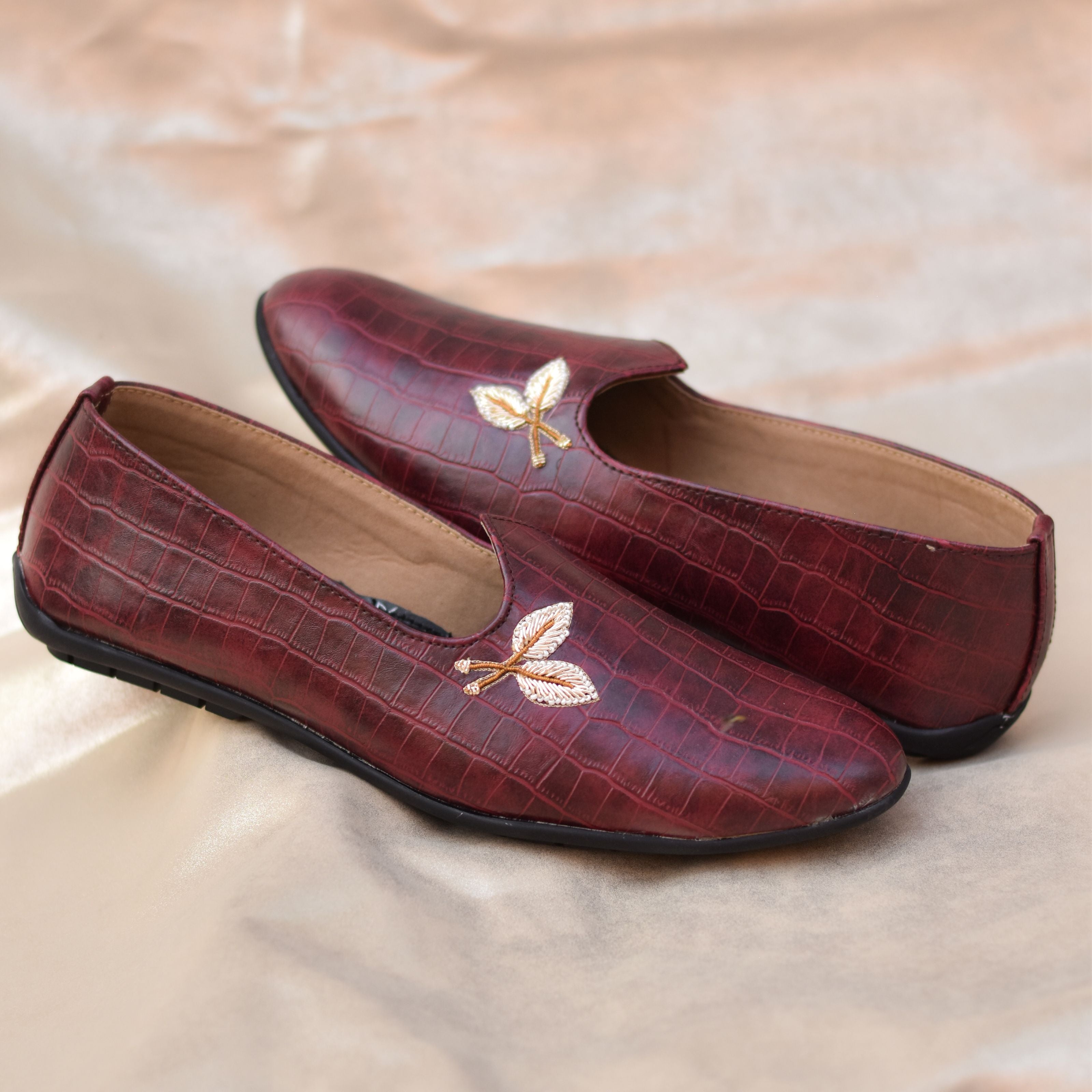 Men's burgundy mojris featuring sleek silhouette and embroidered front motif.