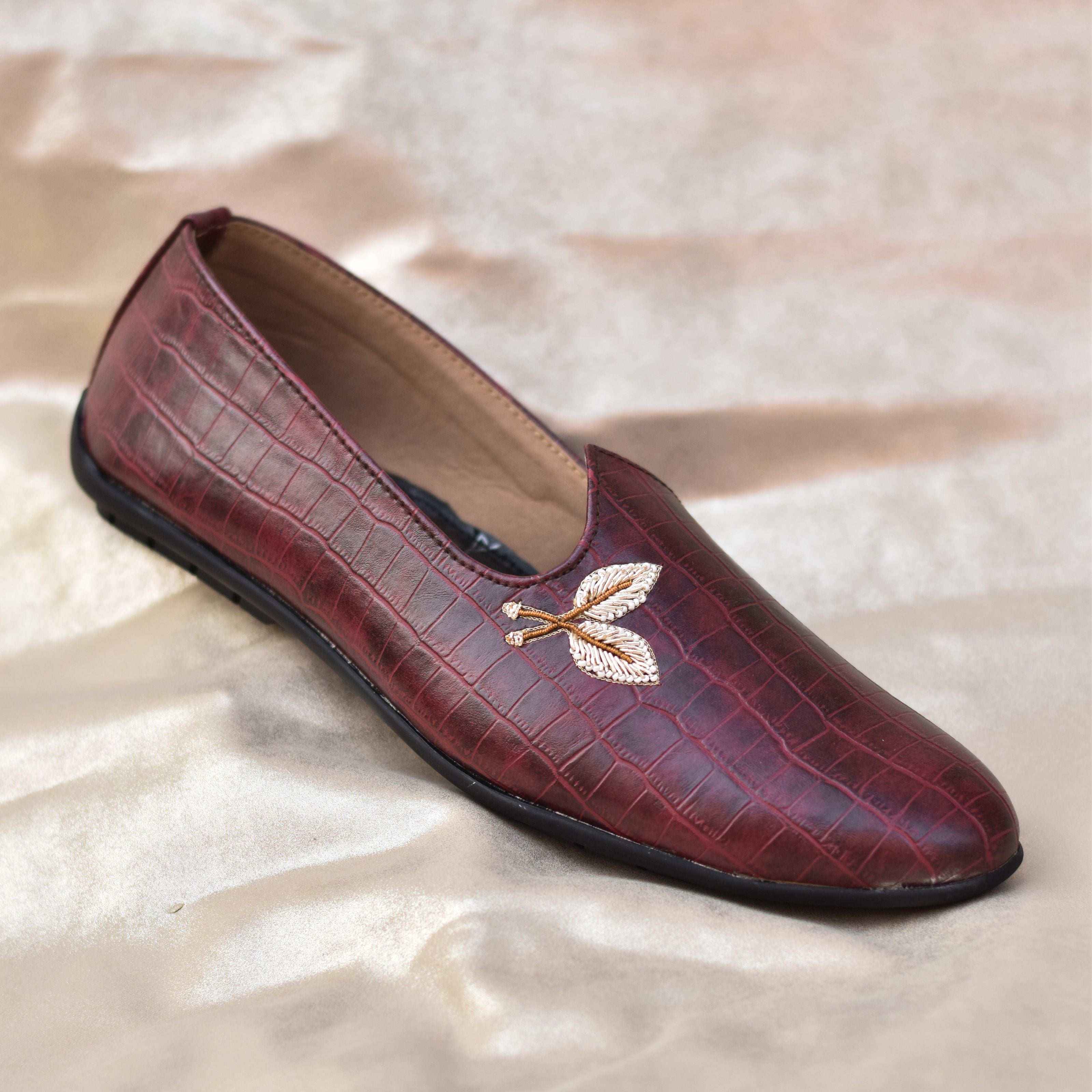 Groom’s textured slip-on shoes in maroon with metallic embroidered detail.