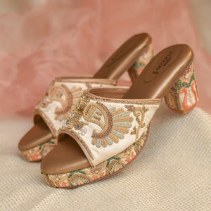 Ivory platform heels with hand-embroidered peacock motif and patterned block heel
