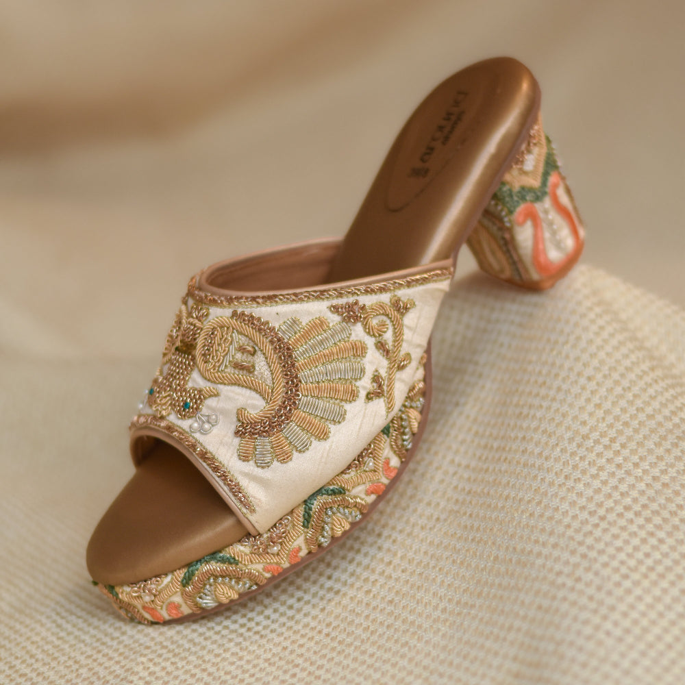 Open-toe ivory heels featuring detailed peacock threadwork with pearl embellishments