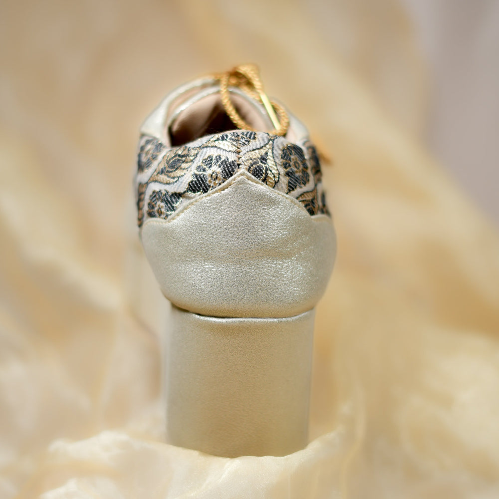 Champagne gold sneaker wedges with brocade-inspired woven patterns and lace-up closure
