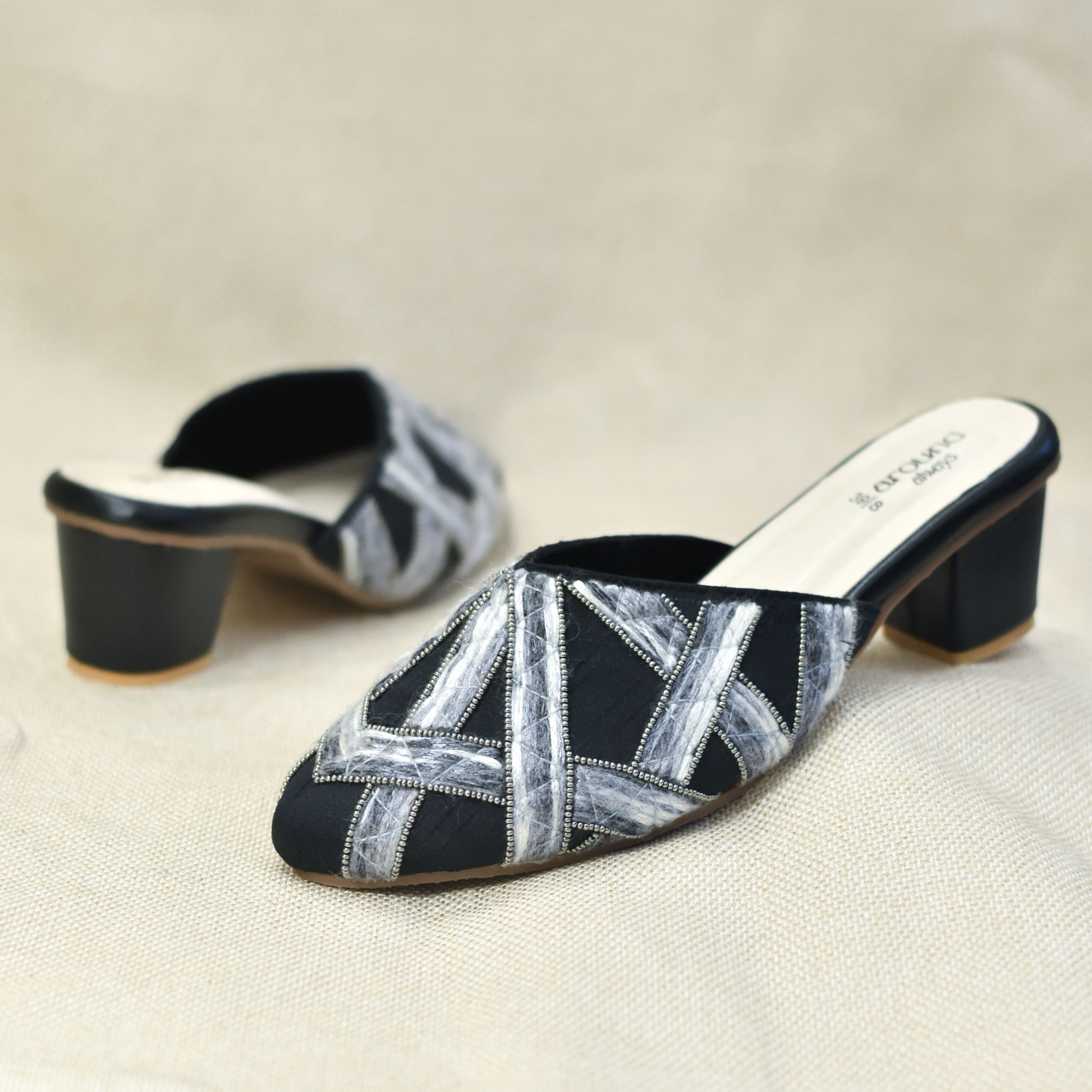 Hand-detailed black slides with structured patterns and block base