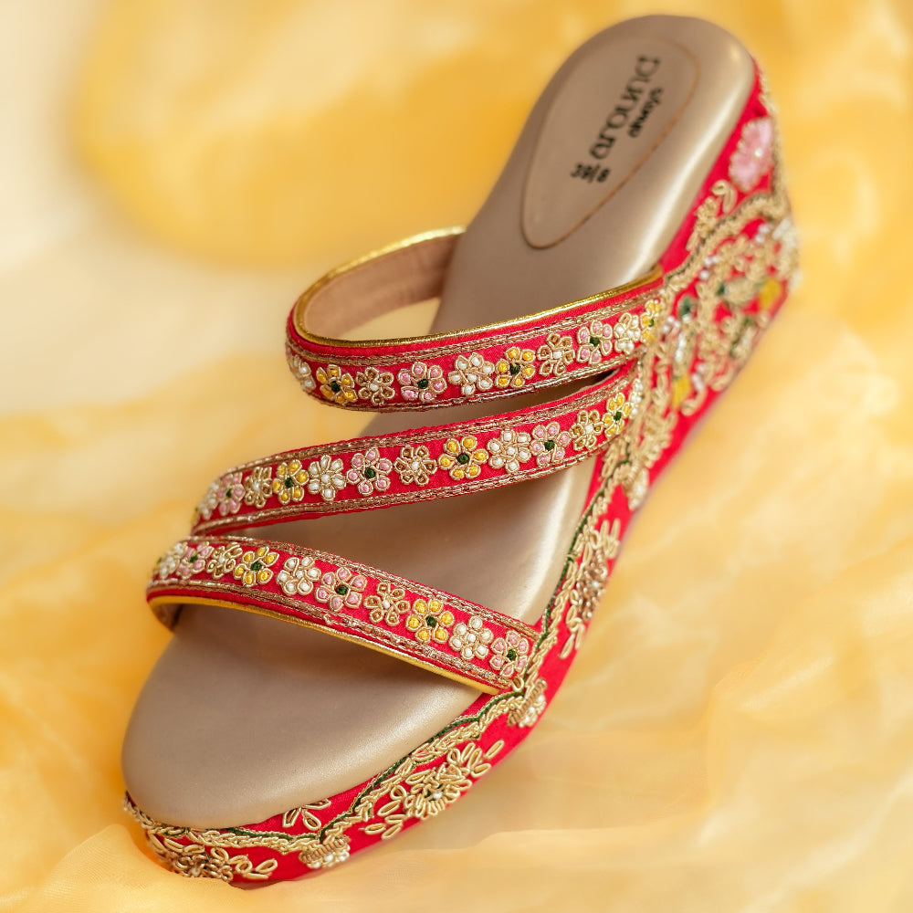 Red embroidered wedge sandals with floral borders and bird motifs
