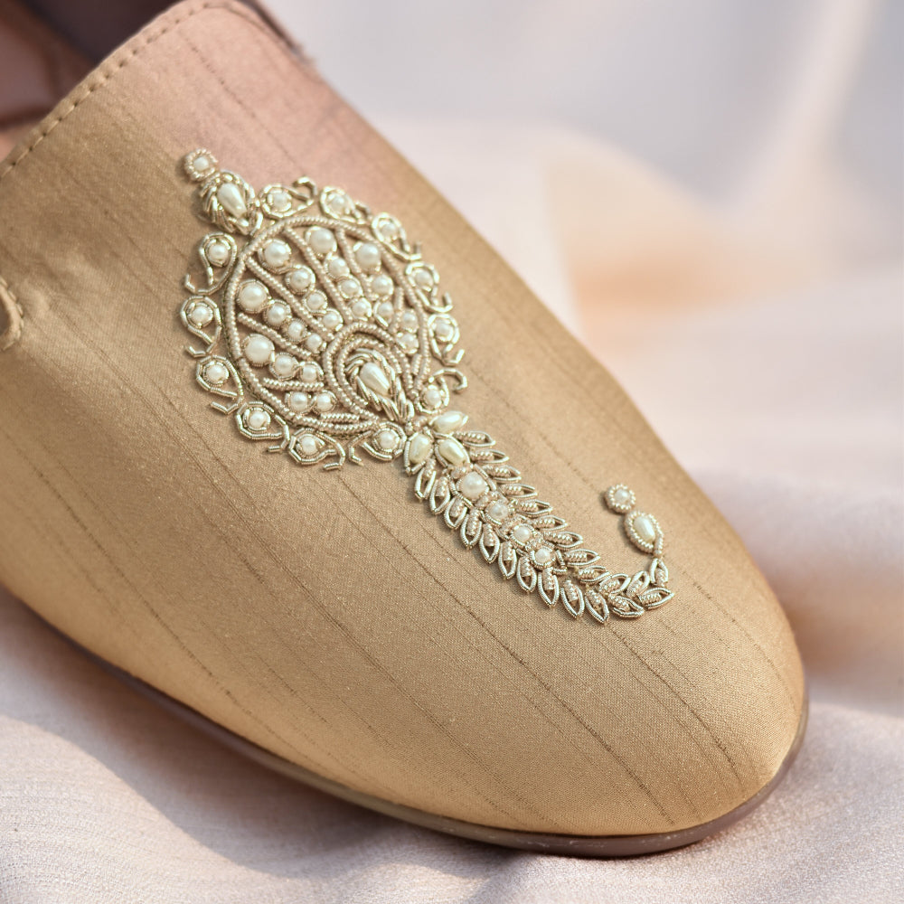 Beige loafer with intricate ivory hand-embroidered motif featuring beadwork and fine thread detailing on a silk-textured base