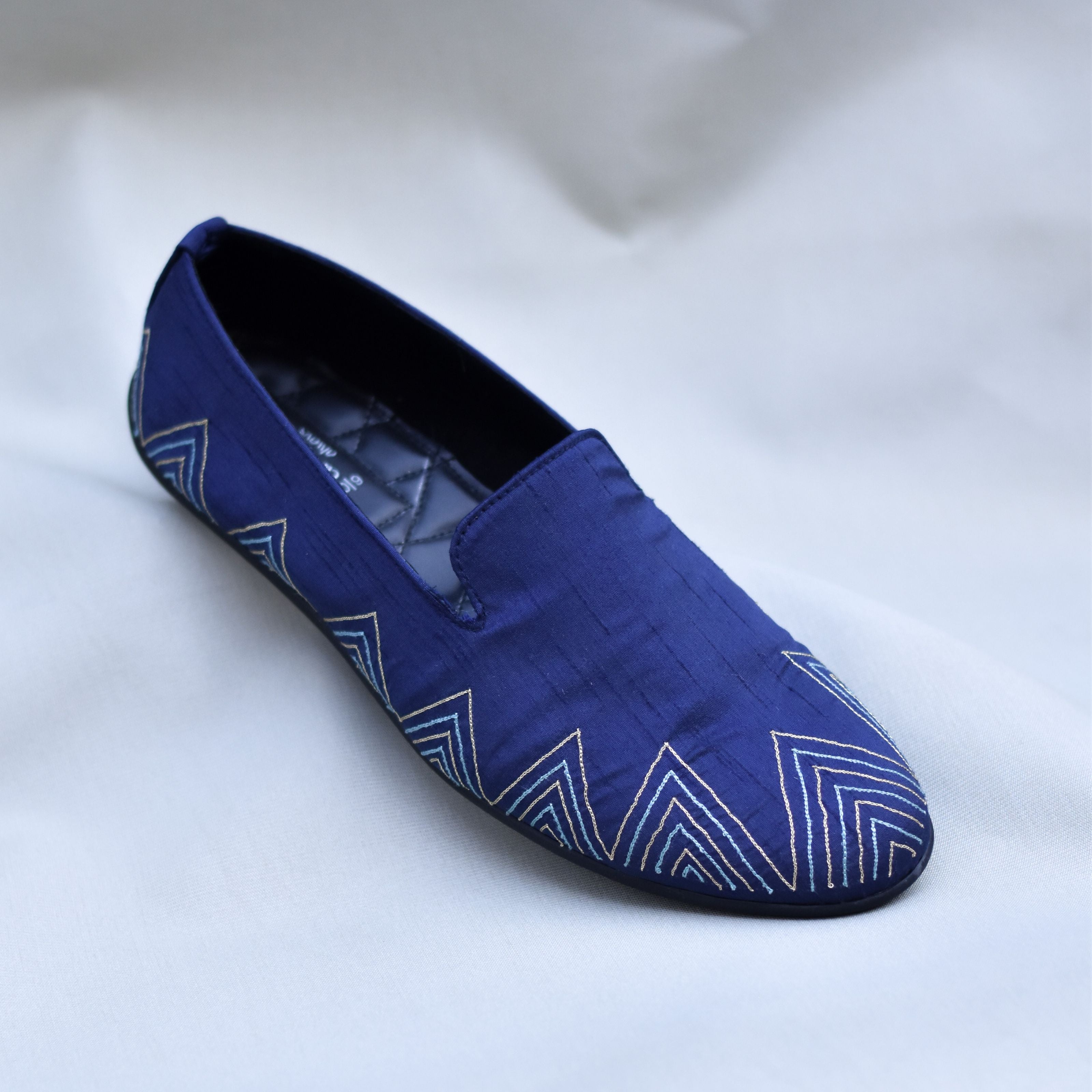 Groom’s navy slip-on shoes featuring geometric layered threadwork.