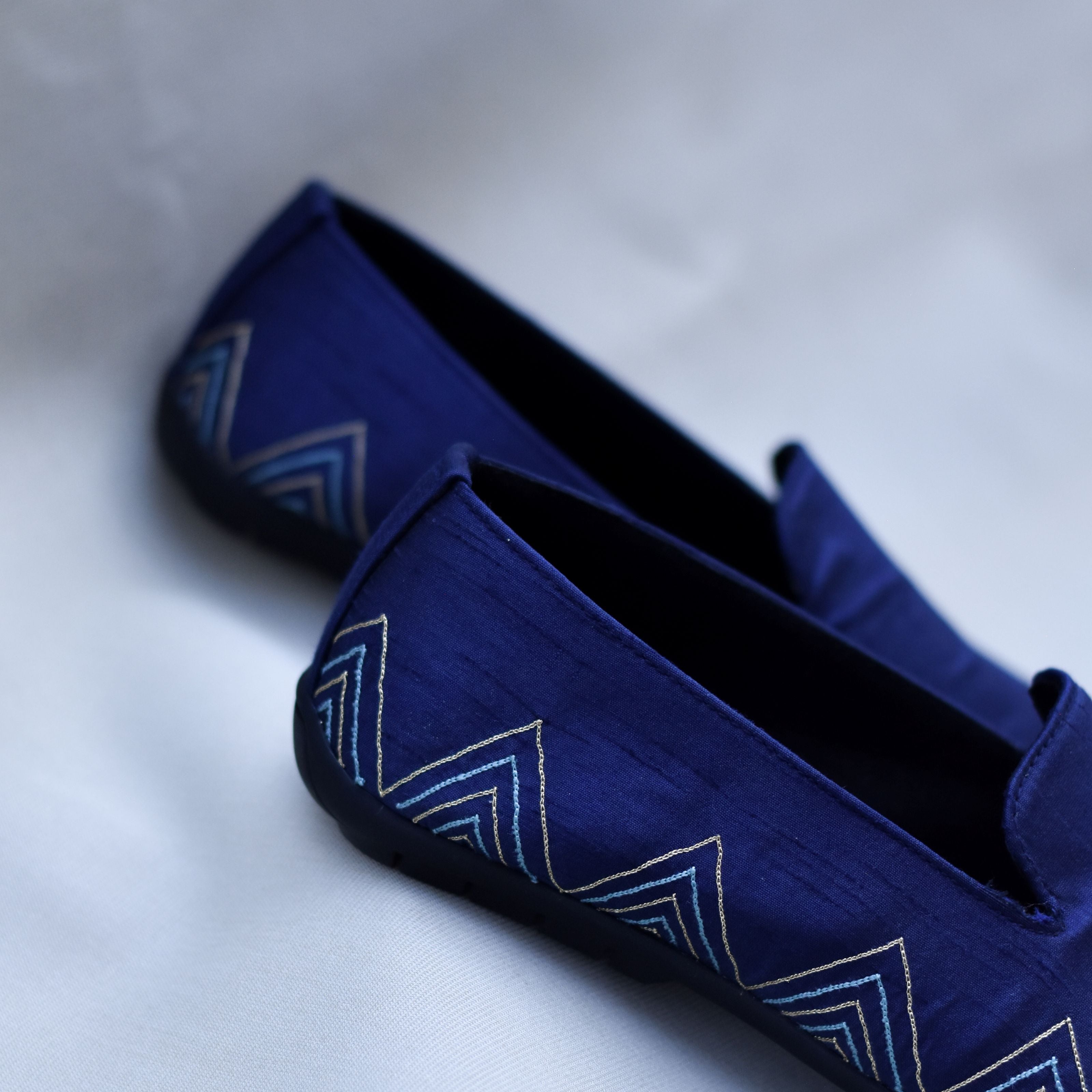 Navy wedding loafers with blue and white chevron embroidery and gold accents.