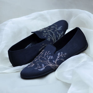 Black groom loafers with metallic embroidery and dark blue bead accents—luxurious wedding shoes for Indian grooms seeking a regal, modern look.