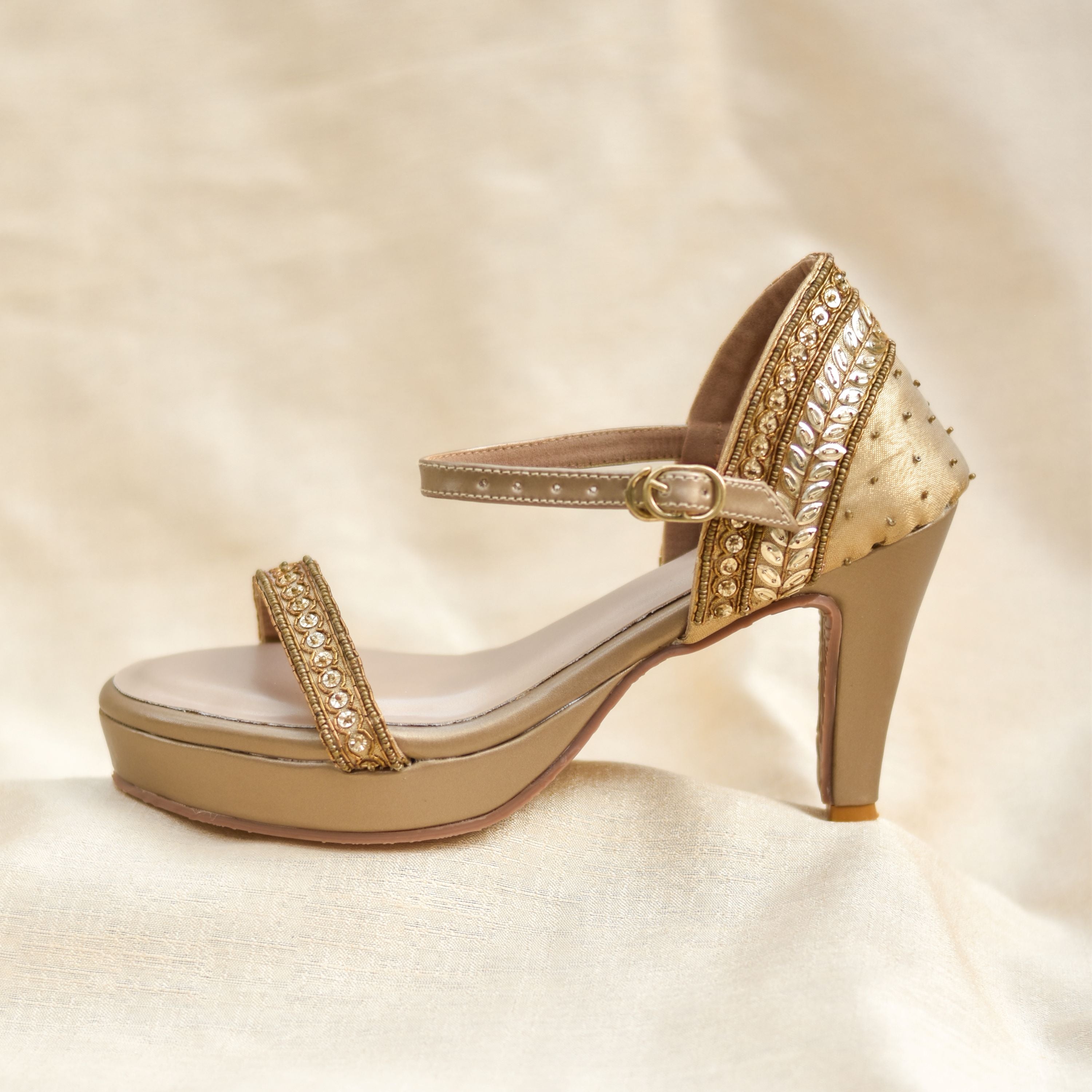 Festive gold sandals with cushioned insole and pencil heel design.