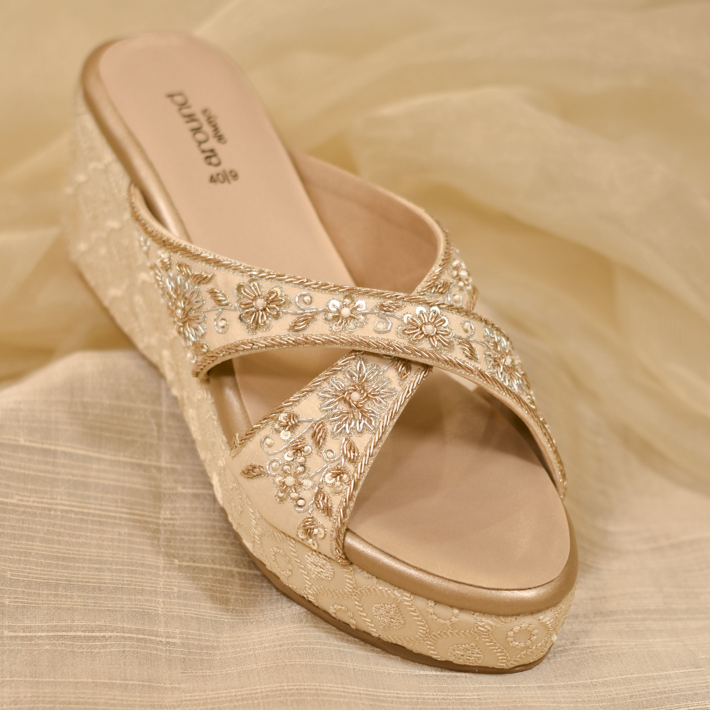 Beige sandal with floral embellishments on a beige fabric base