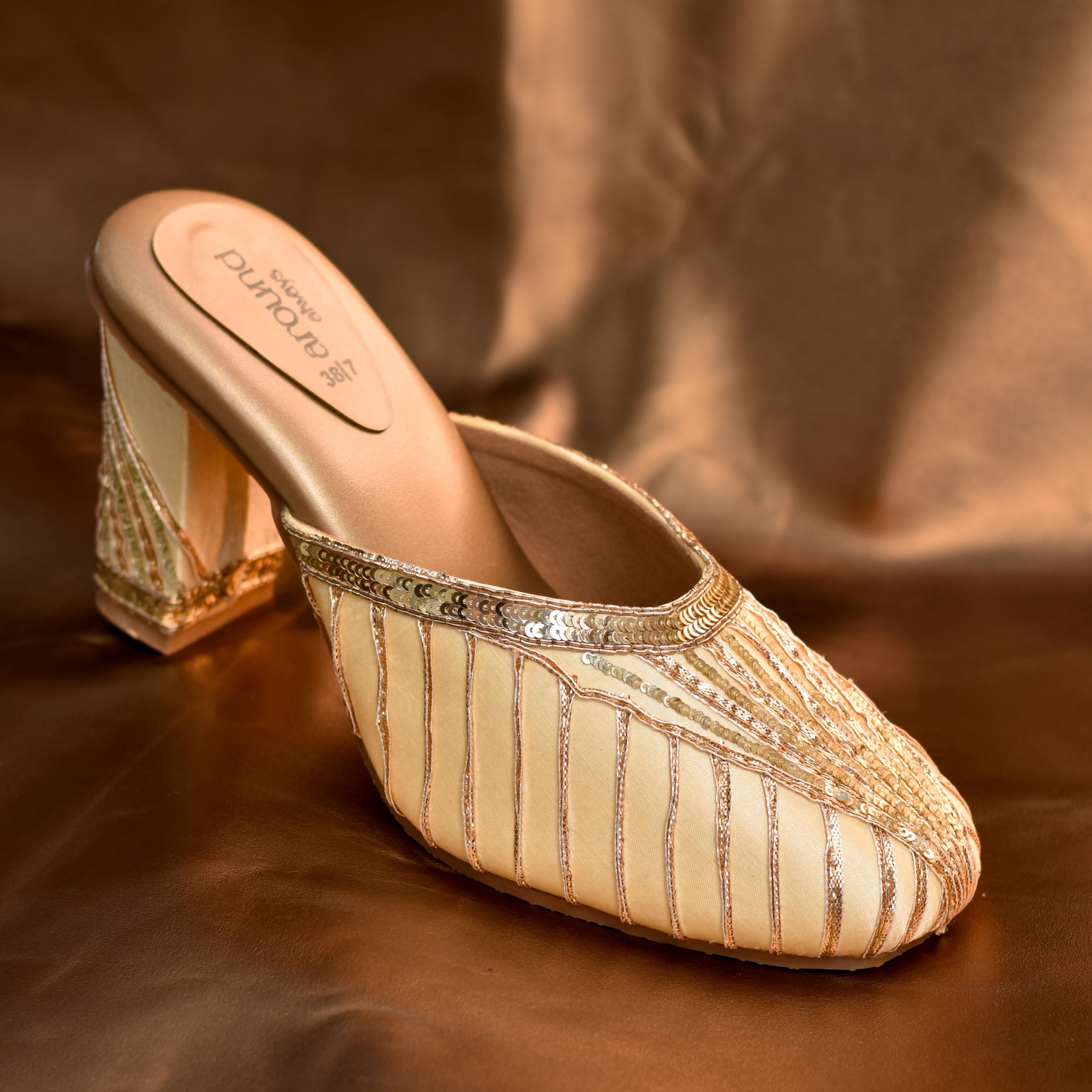 Designer gold wedding mule with soft satin finish and sequin highlights.