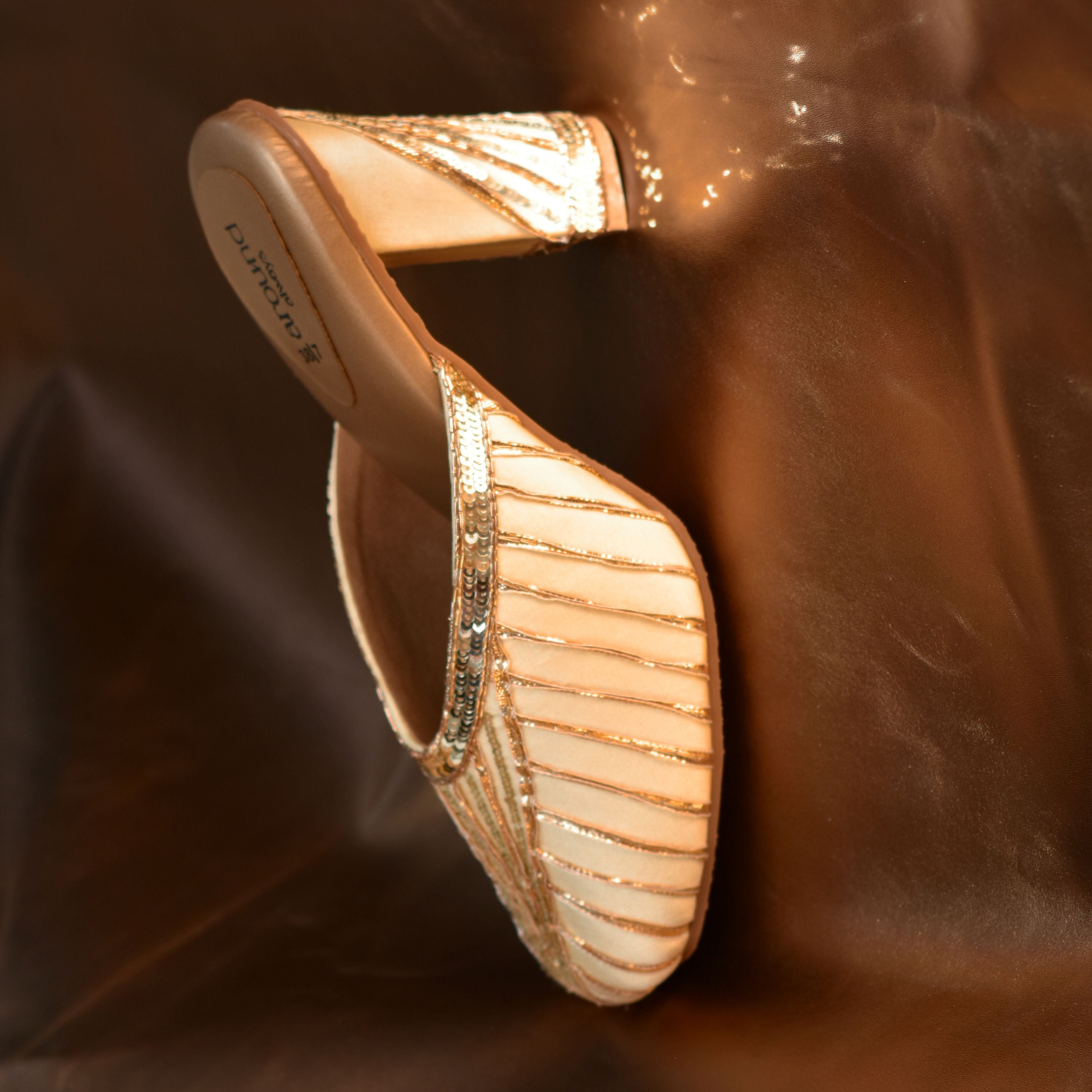 Golden satin block heel mule with sequin stripe detailing.