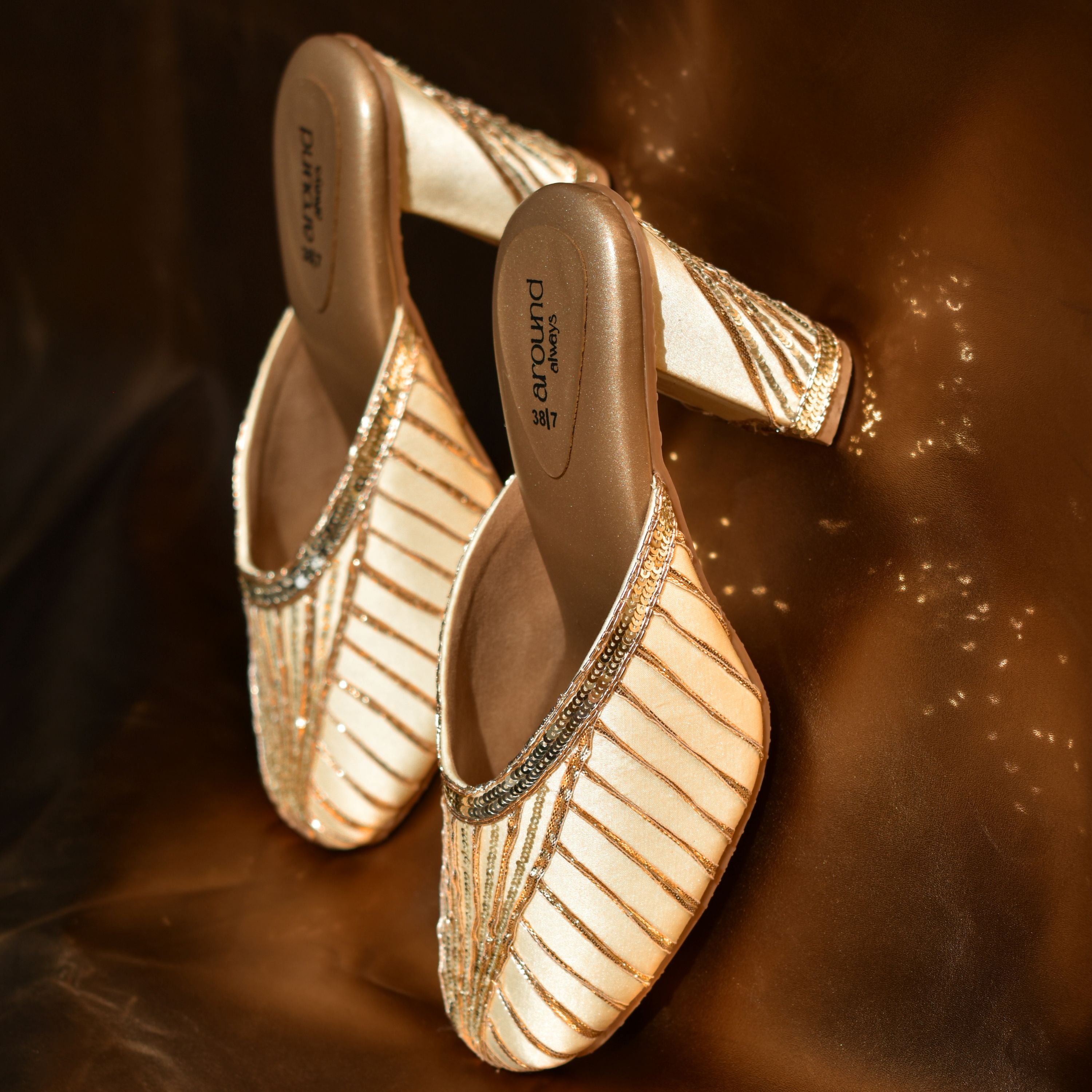 Handcrafted gold-toned closed-toe heels for festive wear.