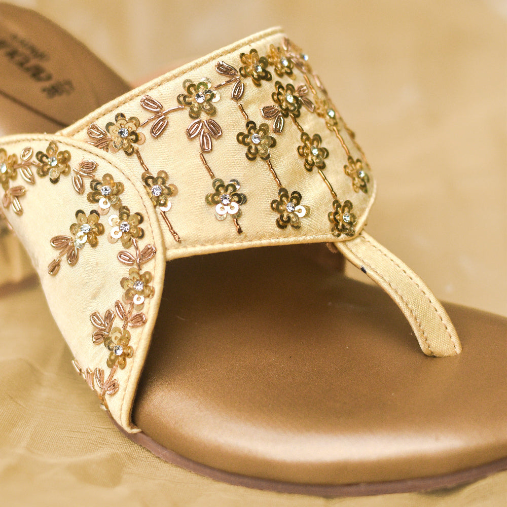 Gold occasion sandals featuring floral embellishments and block heel.
