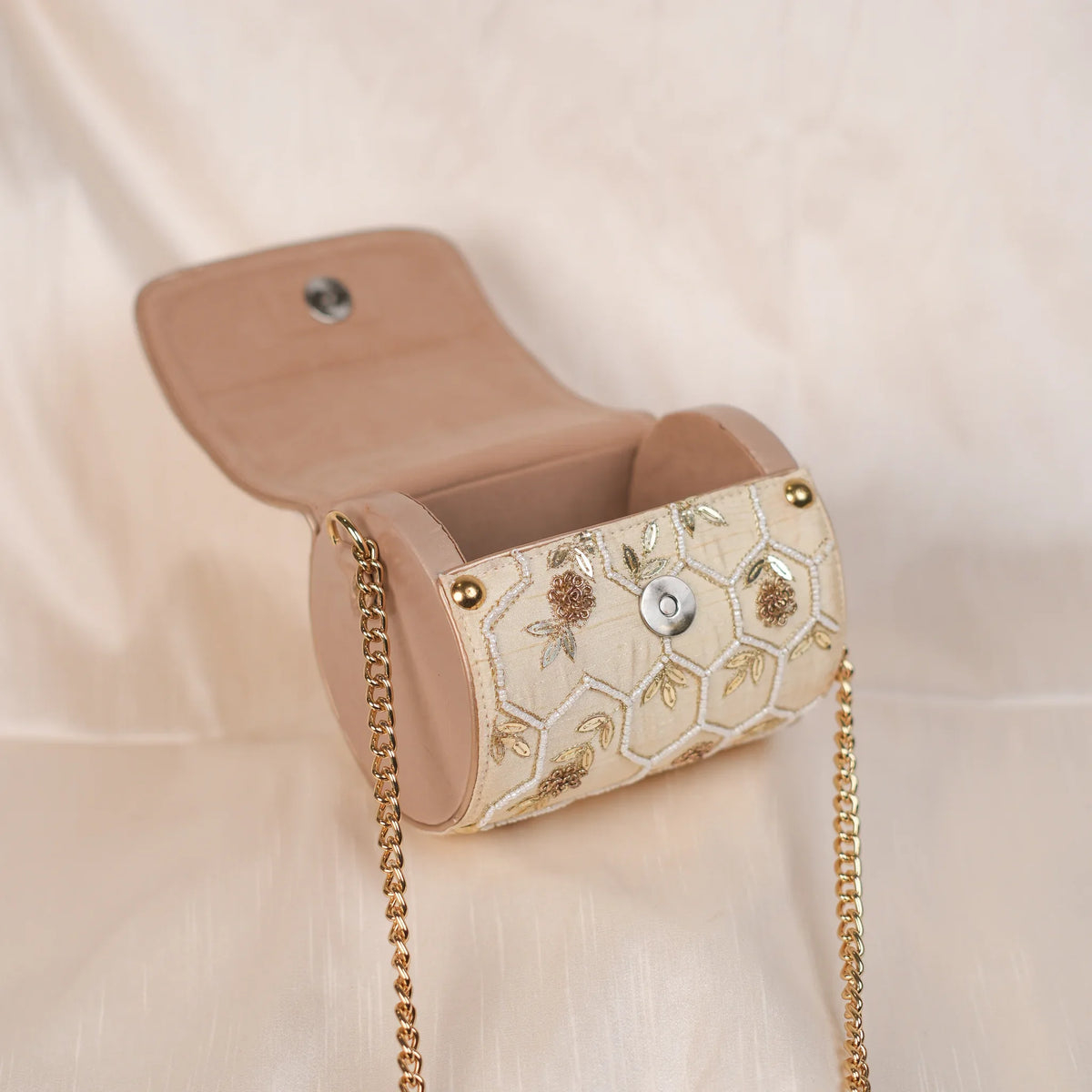 Honeycomb circle clutch open to show the blush lining and magnetic flap