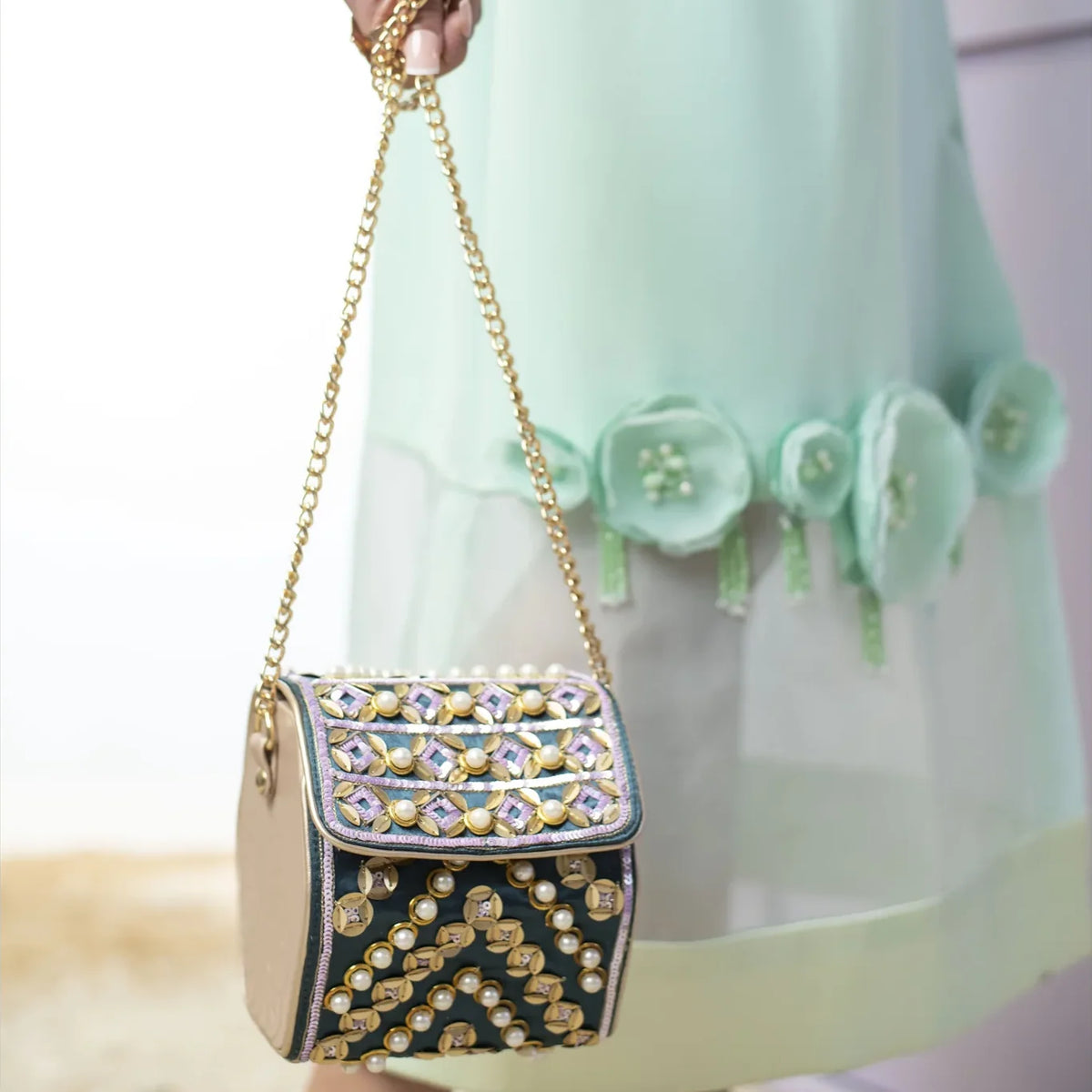 Close view of the Indie hexa bag on its gold chain strap