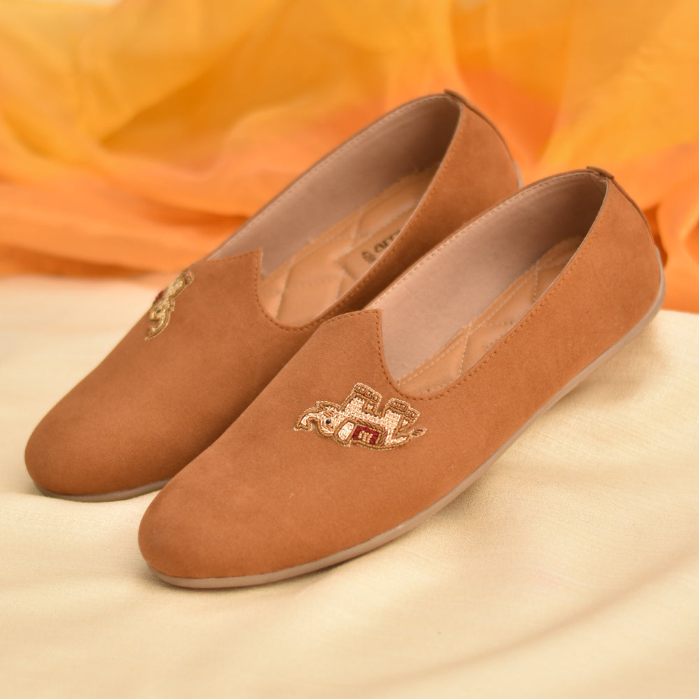 Tan mojri shoes with embroidered elephant motif on the upper
