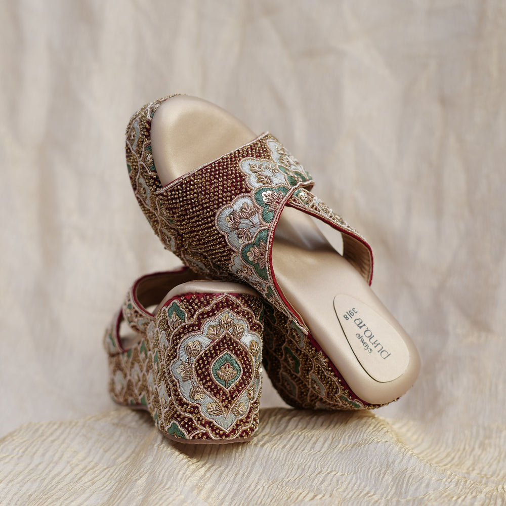 Handcrafted maroon bridal footwear with green and gold panels