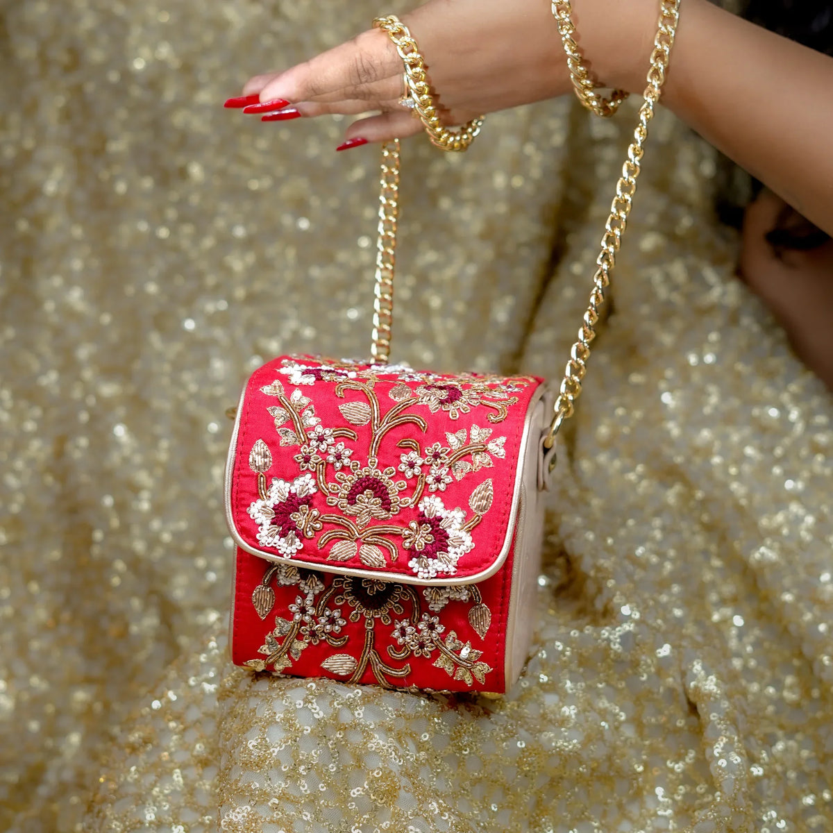 Front view of the red zardozi bridal bag carried in hand