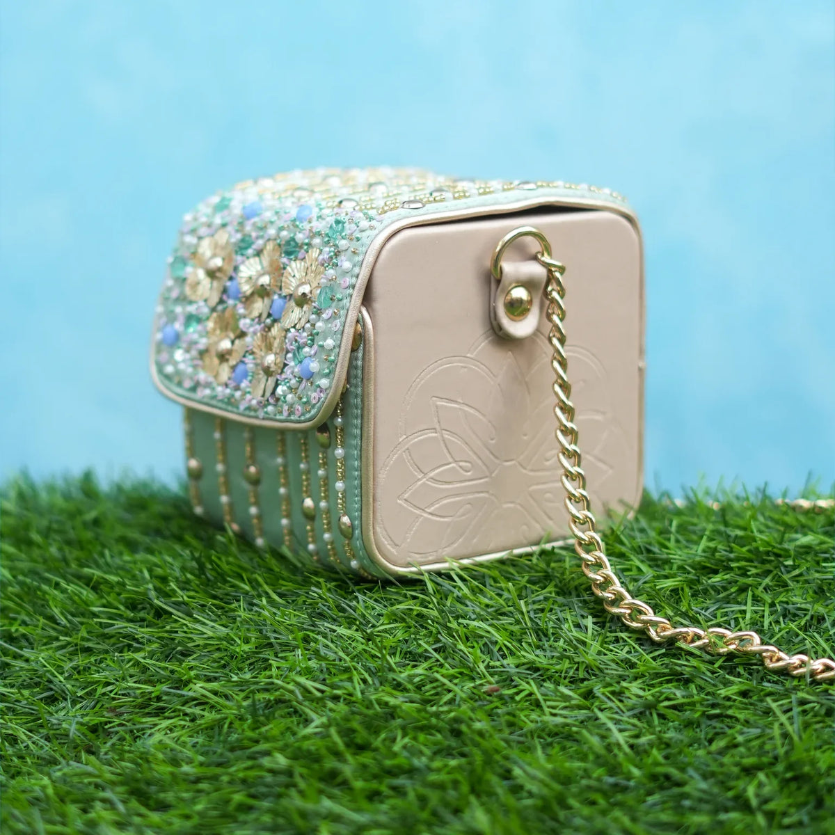 Pixie box bag showing the embellished flap and champagne side