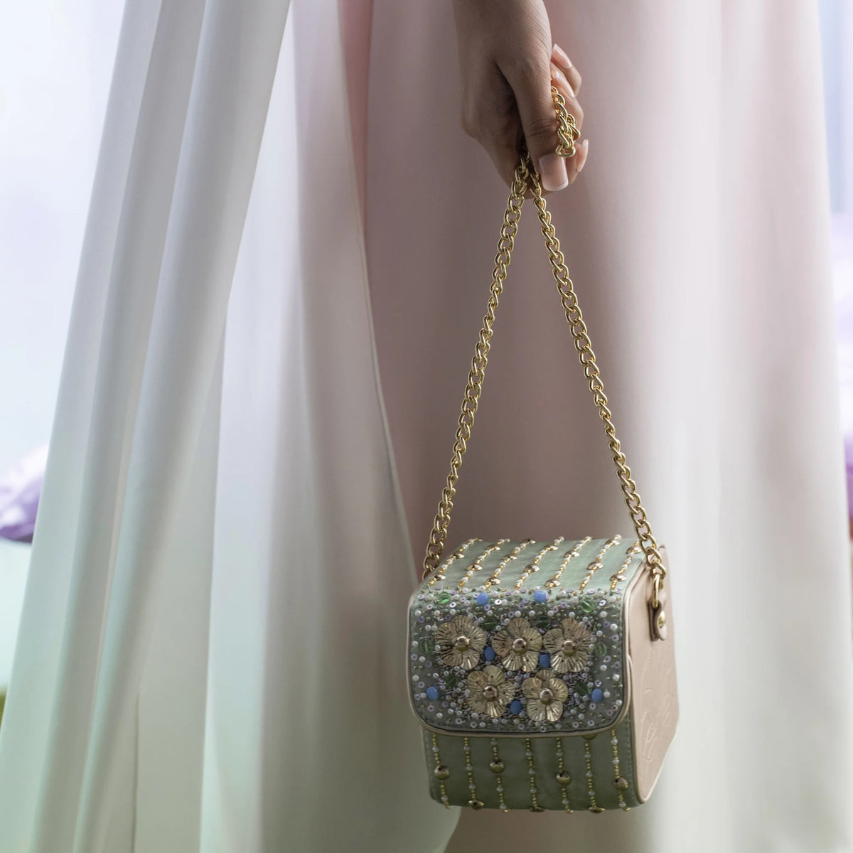 Front view of the Pixie box bag held by its chain