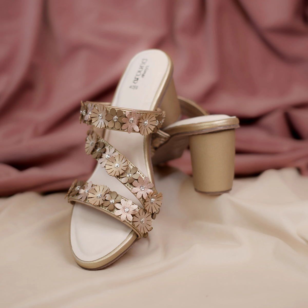 Gold slip on sandals with flower covered straps, side view