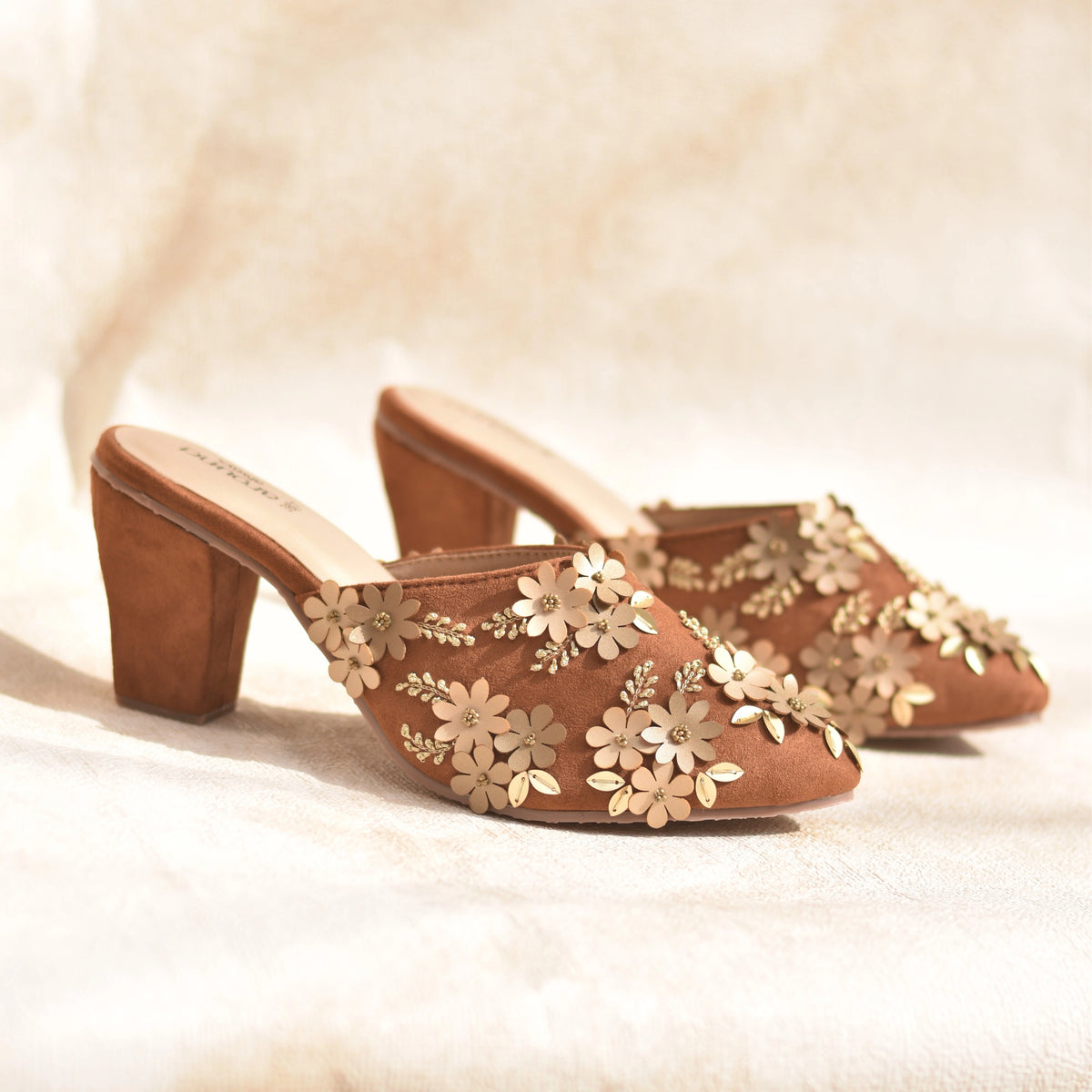 Pair of tan suede festive mules with gold floral embellishment
