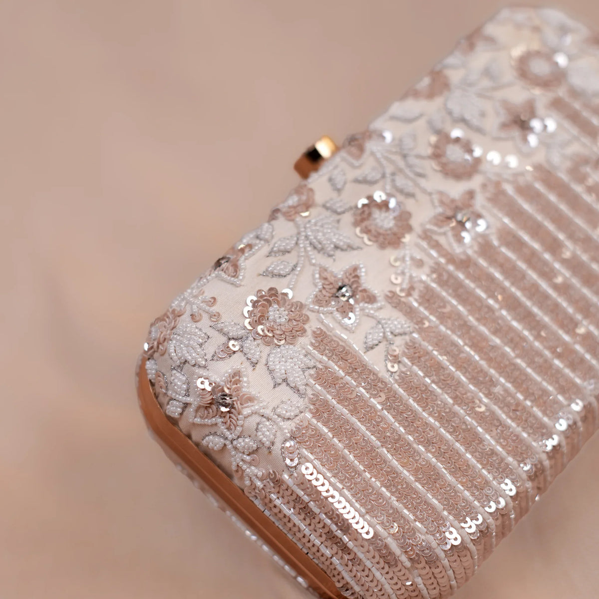 Close-up of hand embroidered thread flowers, sequins and crystals on the Savera ivory clutch