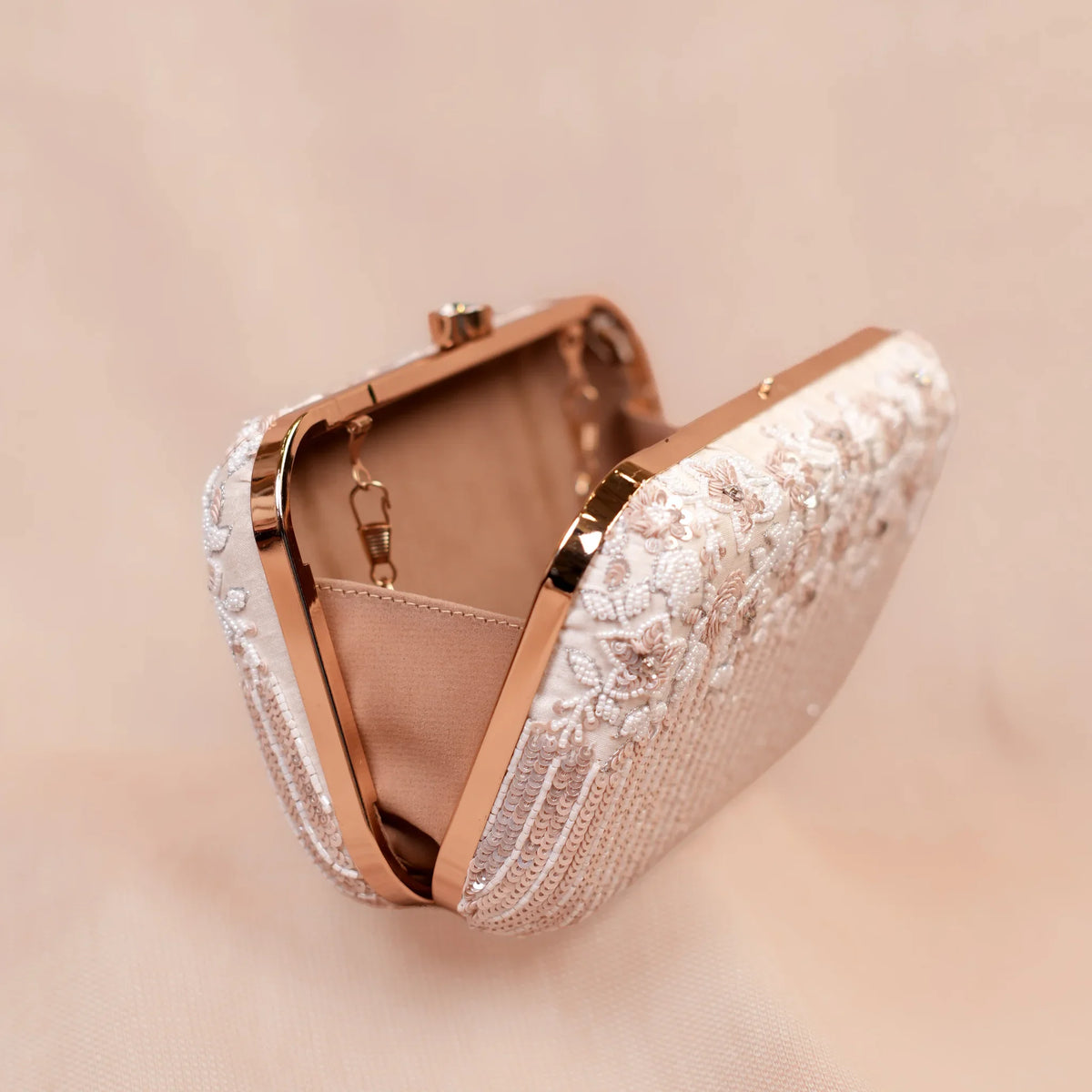 Savera clutch open to show the satin-lined inside and rose gold hard frame
