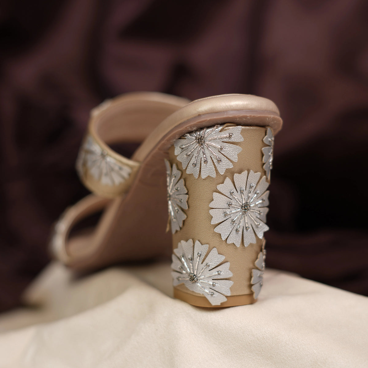 Back view of block heel covered in silver flowers